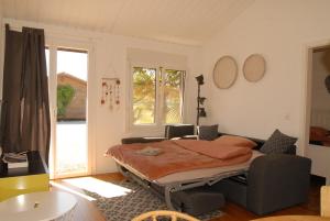 ein Schlafzimmer mit einem Bett, einem Tisch und einem Fenster in der Unterkunft Chalets Vacances in Avenches