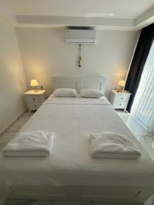 a white bedroom with a large white bed with two pillows at Sweet Home Turunc - Sea View Suites with One Bedroom in Turunç +44 photos