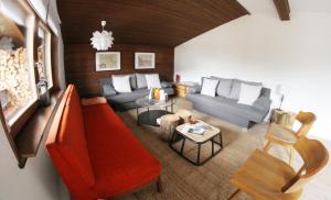 einen Blick über ein Wohnzimmer mit einem roten Sofa in der Unterkunft Family Friendly Chalet - Central with Beautiful Mountain Views in Seefeld in Tirol