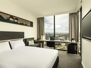 a hotel room with a bed and a large window at ibis Adelaide in Adelaide +56 photos