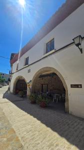 a building with an archway with tables and chairs at Albergue La Cuba in La Cuba