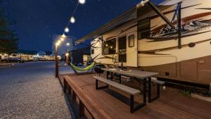 an rv parked on a wooden deck with a table and a bench at Yangyang Hajodae Campingcar in Yangyang