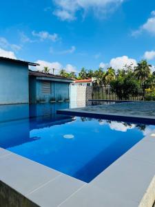 a swimming pool with blue water in front of a house at Catch Up Dambulla in Dambulla