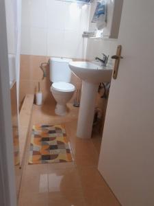 a bathroom with a toilet and a sink at Yellowstone in Kefalos
