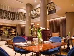 a restaurant with a wooden table and blue chairs at Sofitel Buenos Aires Recoleta in Buenos Aires