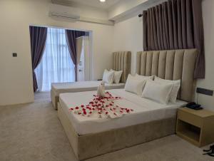 a hotel room with two beds with red roses on the bed at Kings hotel in Colombo