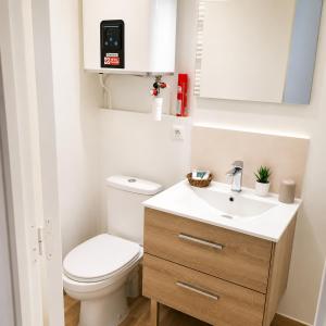 a small bathroom with a toilet and a sink at Les Escales de Choisy in Choisy-le-Roi
