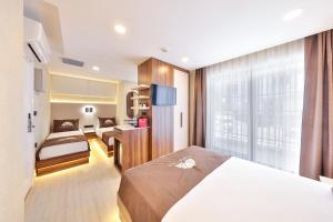 a hotel room with a bed and a window at Sardunya Otel ARKA BİNA in Kaş