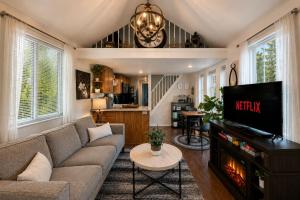 a living room with a couch and a tv at Das Tree Haus by NW Comfy Cabins in Leavenworth