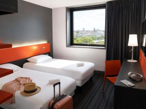 a hotel room with two beds and a window at ibis Styles Caen centre gare in Caen +86 photos
