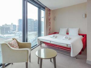 a hotel room with a bed and a large window at Mercure Clermont Ferrand centre Jaude in Clermont-Ferrand +134 photos