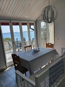 a dining room with a table and views of the ocean at Lillstugan at Sävö in Västerljung