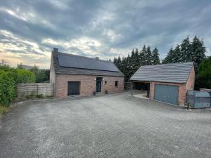 a brick building with a parking lot in front of it at Maison avec piscine à Dinant in Sorinnes
