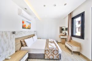 a hotel room with a bed and a window at Sardunya Andifli Otel in Kaş