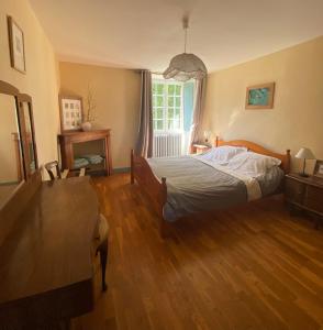 a bedroom with a bed and a table and a window at Manoir La Buissonnière in Plescop