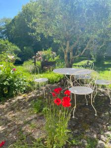 a table and chairs and flowers in a garden at Manoir La Buissonnière in Plescop