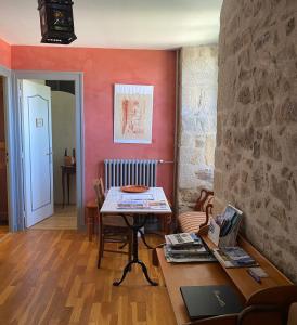 a dining room with a table and a wall at Manoir La Buissonnière in Plescop