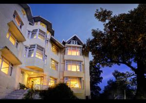 a large white building with many windows at night at Summit Le Royale Hotel, Shimla in Shimla