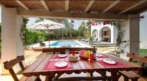a wooden table with a meal on it next to a pool at La Vijanera in Sant Jordi