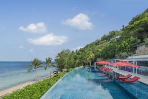 a swimming pool next to the beach at a resort at Conrad Koh Samui in Taling Ngam Beach