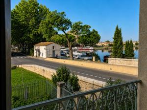 a view of a street and a river with boats at LE PALMIER Aigues-Mortes Petite Camargue in Aigues-Mortes