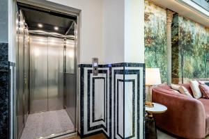 a walk in shower in a room with a couch at Gold Artè Collection in Florence