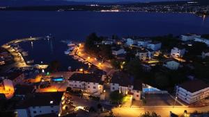 a view of a town at night with the water at Boutique Resort Villa VISTA in Malinska