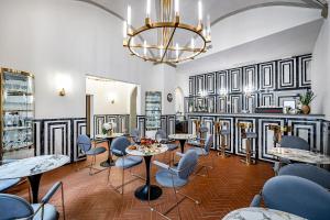 a room with chairs and tables and a chandelier at Gold Artè Collection in Florence