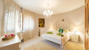 a bedroom with a white bed and a chandelier at La Vijanera in Sant Jordi