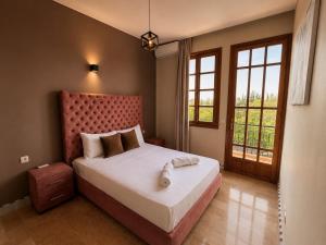 a bedroom with a large bed with a red headboard at Elegant, quiet villa in Marrakesh