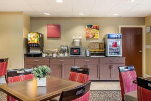 a restaurant with a table and chairs and a counter at Comfort Suites Gastonia - Charlotte in Gastonia