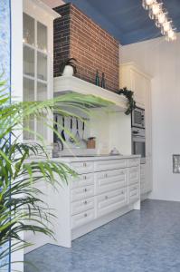 a kitchen with white cabinets and a brick wall at Business Home Vienna in Vienna