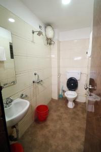 a bathroom with a sink and a toilet and a mirror at Hotel best buy in Kolkata