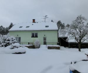 una casa cubierta de nieve frente a un patio en Privát Folprechtovi, en Dobšín