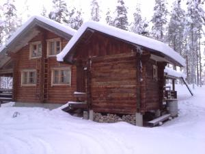 a log cabin with snow on top of it at Kuulapää Chalet in Äkäslompolo
