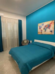 a blue bedroom with a bed with a blue wall at Apartment La Conchiglia in Menfi