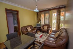 a living room with leather furniture and a table at Crystal Suites & Apartments in Kampala