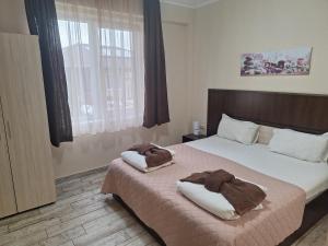 a bedroom with a bed with two towels on it at Вилен комплекс Дарибел in Sapareva Banya +73 photos