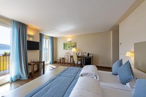 a bedroom with a bed and a living room at Hotel Baia D'Oro - Adults Only in Gargnano