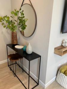 a black table with a mirror on a wall at "Univeristy" Charming Craftsman - 3 bd, 2ba in Riverside in Riverside