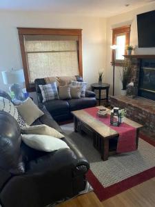 a living room with a leather couch and a coffee table at "Univeristy" Charming Craftsman - 3 bd, 2ba in Riverside in Riverside