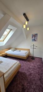 a bedroom with two beds and a cross on the floor at Hotel Vacek Pod Věží in Hradec Králové +72 photos