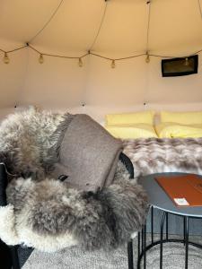 a bed in a tent with a blanket and a table at Torshaug glamping in Trondheim