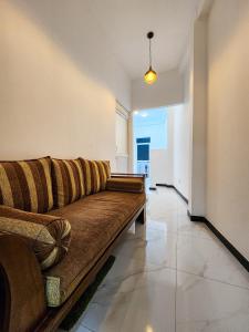 a living room with a brown couch in a room at Silva Nest Recidencies in Galle