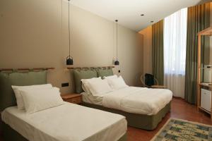 two beds in a hotel room with two bedsskirts at Green Park Divjake in Divjakë
