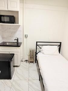 a small bedroom with a bed and a sink at Adrian Hotel in San Francisco