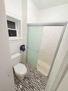 a bathroom with a toilet and a glass shower at Adrian Hotel in San Francisco +41 photos