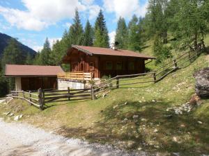 una cabaña de madera en una colina junto a un camino de tierra en Puellgut, en Flachau