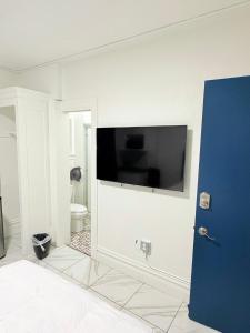 a bathroom with a toilet and a television on a wall at Adrian Hotel in San Francisco