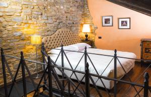 モンフォルテ・ダルバにあるDimora I Manicheiのベッドと石の壁のある寝室 +43枚の写真